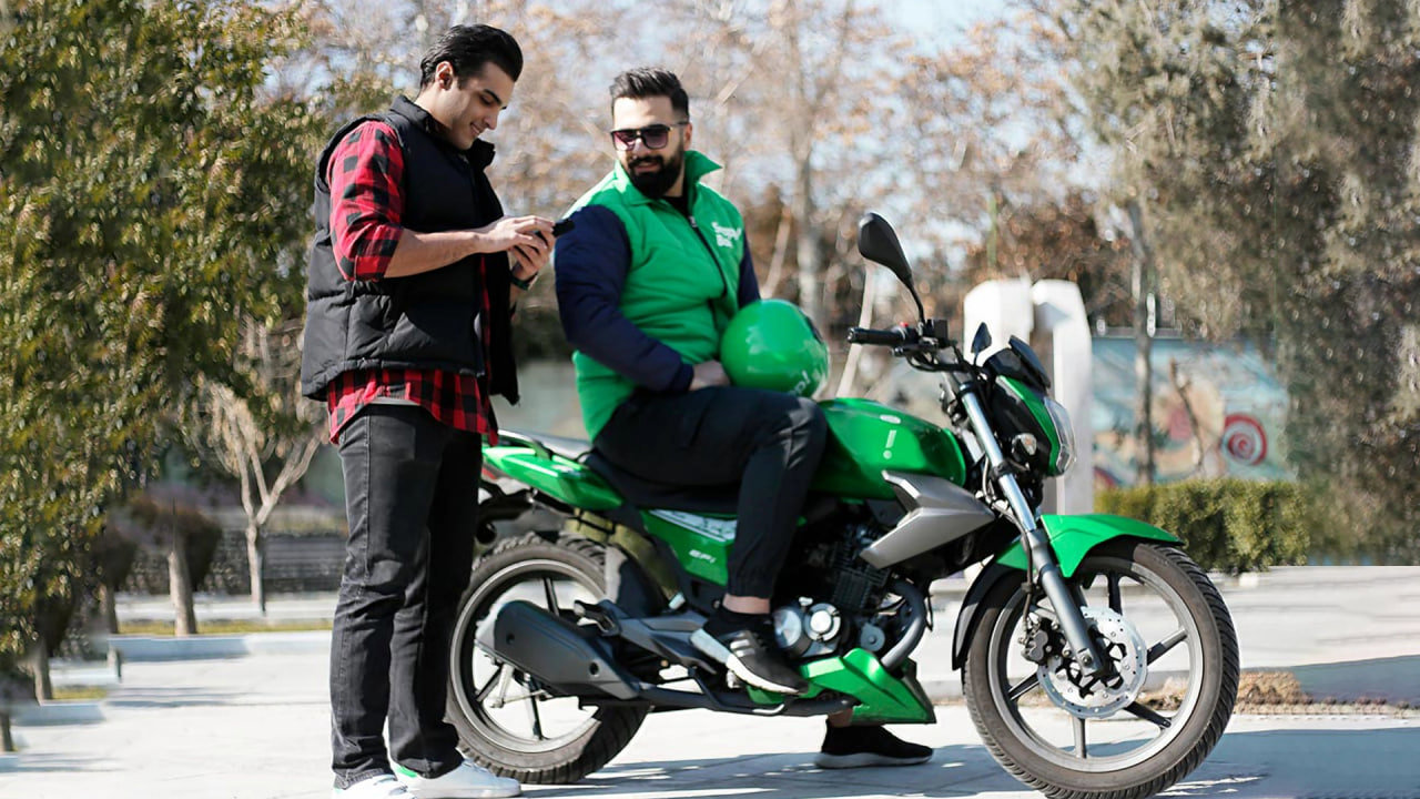 راکب موتور اسنپ در کنار مسافر پیش از شروع سفر